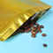 Η χρυσή συσκευασία φασολιών καφέ συνήθειας, στέκεται επάνω την τσάντα σακουλών με τη βαλβίδα προμηθευτής